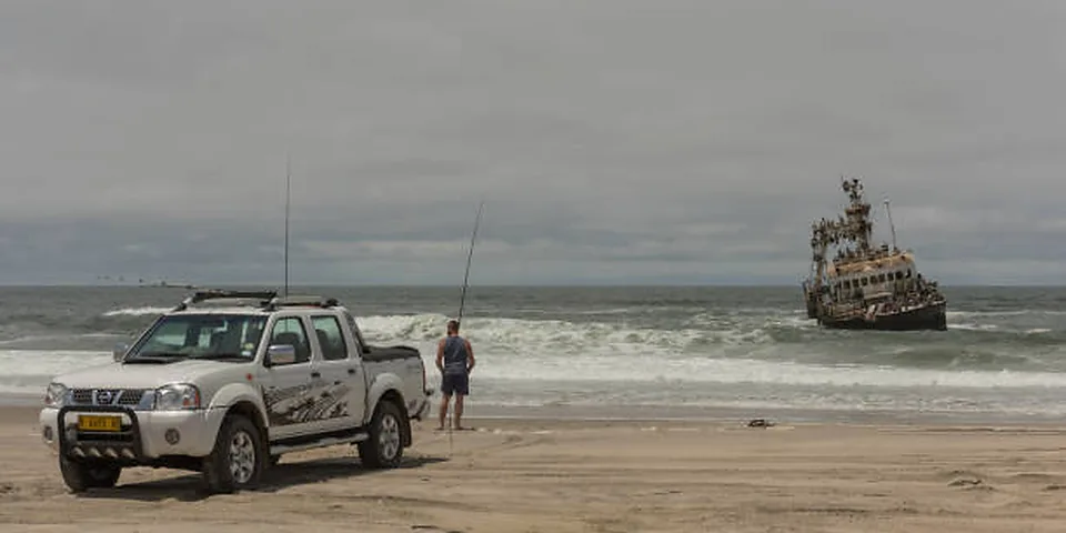 Fishing rod beside quiet coastal water with no people or text