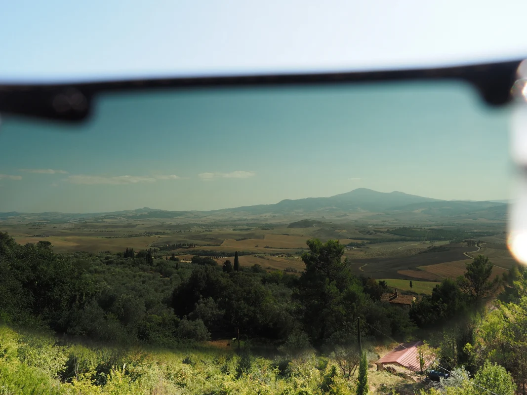 Polarized sunglasses framing a scenic Tuscan landscape