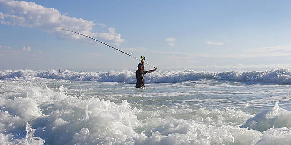 Fishing rod on a shoreline between an inland lake and coastal water